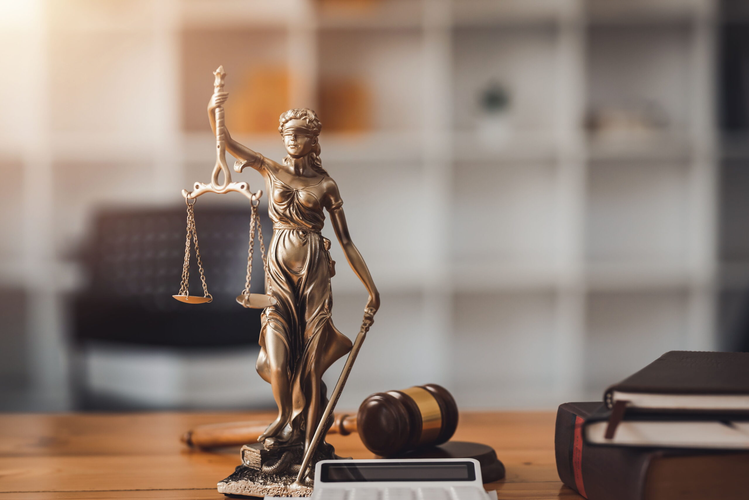 Statue of Lady Justice on a wooden desk, symbolizing the fair legal representation provided by a Vista criminal defense attorney.