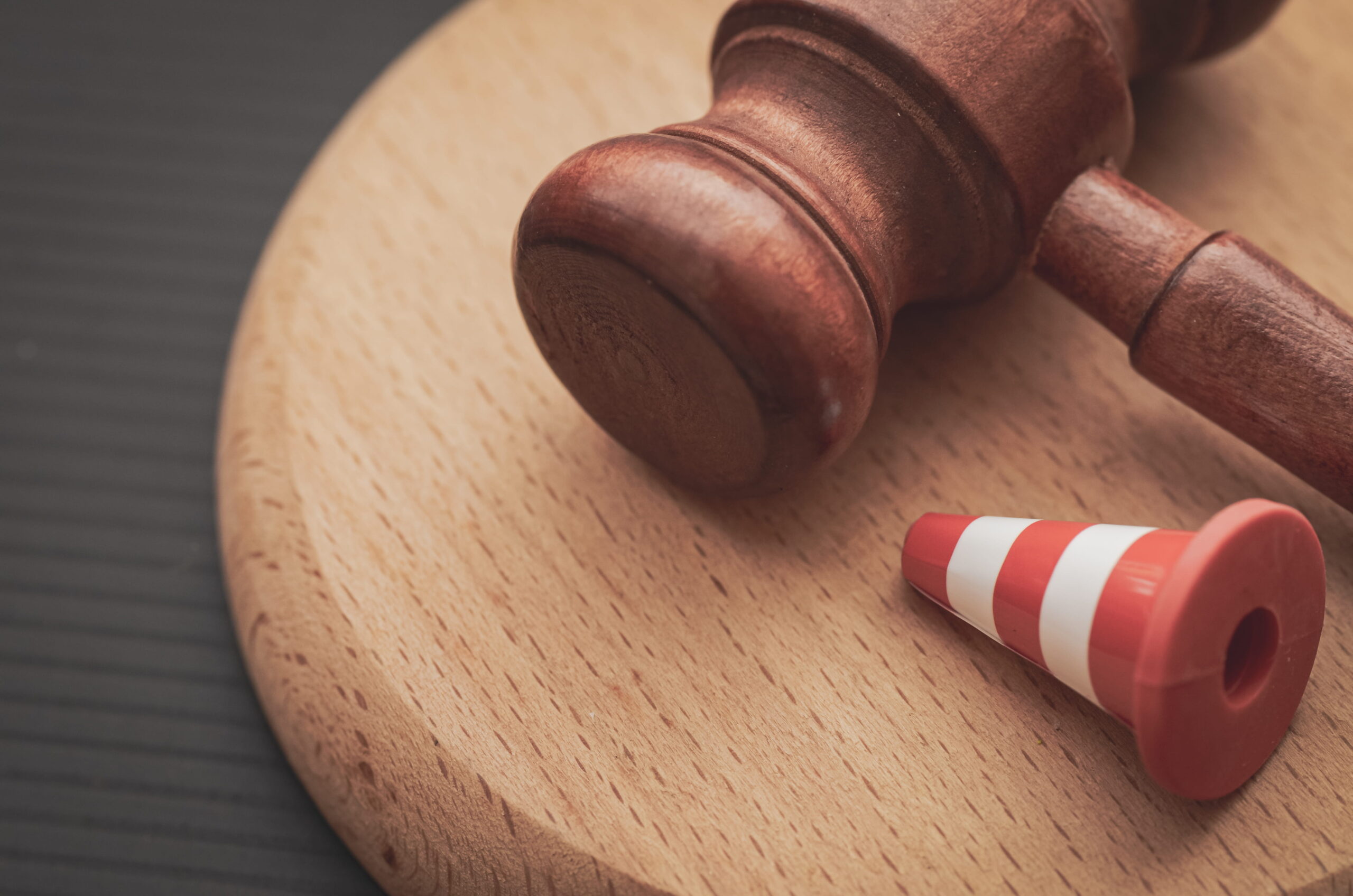 A judicial gavel next to a traffic cone, symbolizing the legal defense provided by a Rancho Santa Fe criminal defense attorney for DUI and traffic violations.
